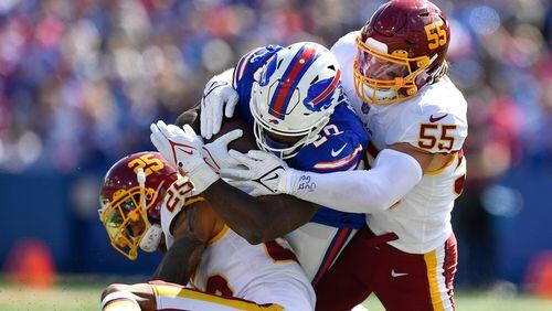 Washington Football Team's Cole Holcomb (55) and Benjamin St-Juste (25) tackle Buffalo Bills' Zack Moss (20) during the first half Sunday, Sept. 26, 2021, in Orchard Park, N.Y. (Adrian Kraus/AP)