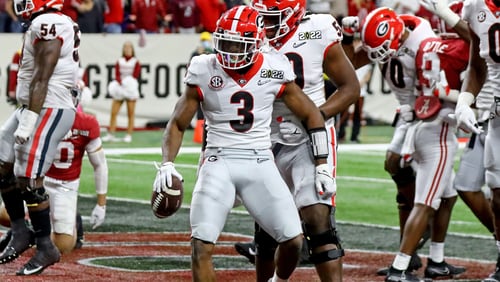 Georgia Bulldogs running back Zamir White (3) celebrates his 1-yard touchdown run with offensive lineman Broderick Jones (59) and tight end Darnell Washington (0) during the third quarter against the Alabama Crimson Tide at the 2022 College Football Playoff National Championship at Lucas Oil Stadium in Indianapolis on Monday, January 10, 2022. Curtis Compton / Curtis.Compton@ajc.com