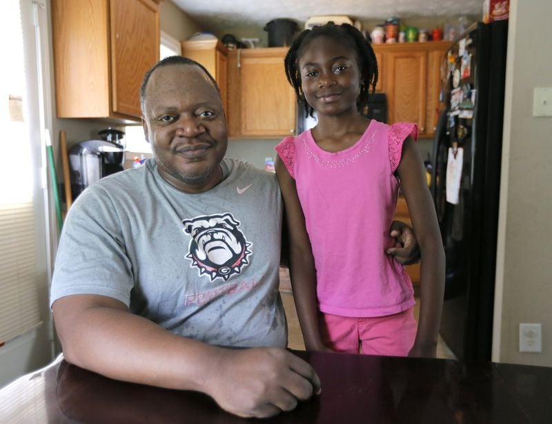 6/5/17 - Conley, GA - Eric Grant, photographed with his daughter, Janiya, 9, used to be on food stamps, but now he’s not. Some 400,000 fewer Georgians are collecting food stamps now compared to 2014, when the number peaked at 2 million recipients. The decrease has been a boon in the lives of people who struggled through the recession, as well as taxpayers.