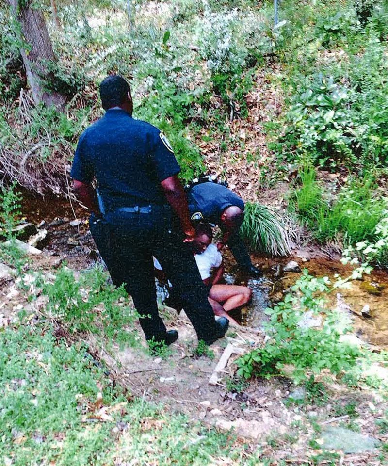 A witness photographed former East Point police officers, Cpl. Howard Weems and Sgt. Marcus Eberhart, as they tried to get Gregory Lewis Towns Jr. to stand after they chased him almost a mile. (HANDOUT photo provided by Chris Stewart)