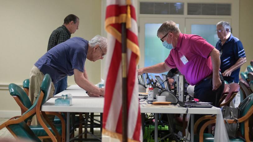 Poll workers assist early voters in May at the Tim D. Lee Senior Center in Marietta. (Natrice Miller / natrice.miller@ajc.com)