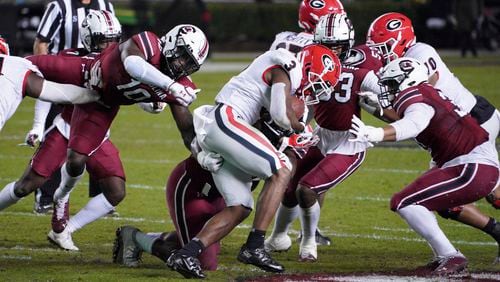 Georgia running back Zamir White (3) carries the ball against South Carolina defensive back Rodricus Fitten (10) and Damani Staley (right) during the first half Saturday, Nov. 28, 2020, in Columbia, S.C. Georgia won 45-16. (Sean Rayford/AP)