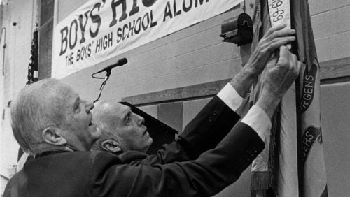 This is a 1984 photo of the Second Annual Boys High School Alumni Association reunion.  Albert Jones (left), Class of 1934 and Bernie Abrams, Class of 1943, look at ROTC  flag and anniversary banners. (AJC FILE PHOTO)