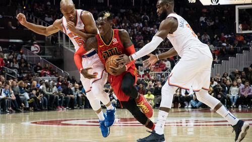 Atlanta Hawks guard Dennis Schroder, of Germany, tries to split the defense of New York Knicks guard Courtney Lee (5) and forward Tim Hardaway Jr. (3) during the first half of a NBA basketball game, Friday, Nov.24, 2017, in Atlanta. (AP Photo/John Amis)