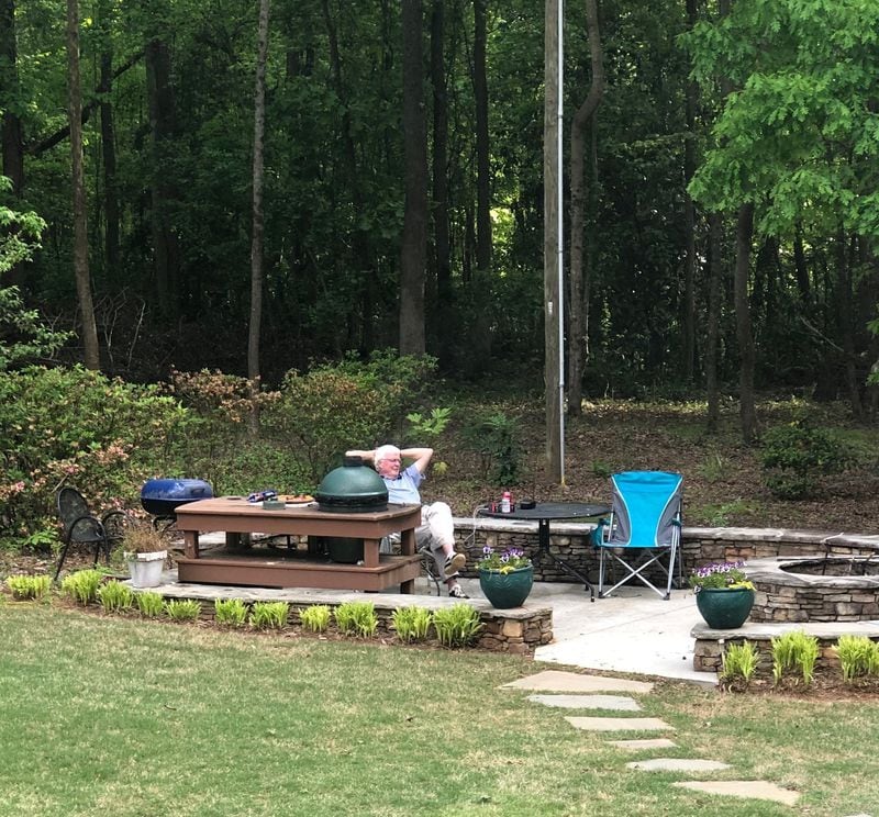 Bill Hollis, the author’s uncle, lounges alongside his Big Green Egg in what his son describes as his “outdoor man cave.” FAMILY PHOTO