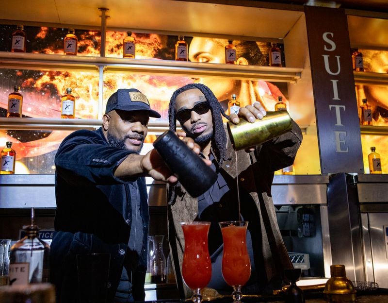 Rapper Quavo, right, partners with White X Cognac and makes a Huncho Hurricane under the direction of mixologist Ben Carrington, left, during a tasting at Suite Lounge on Wednesday, January 24, 2024.  (Jenni Girtman for The Atlanta Journal-Constitution)