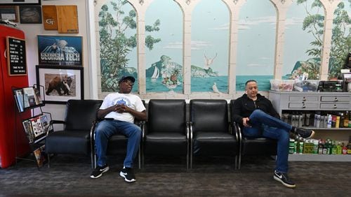 Sulaiman Smith (left), shoeshiner, and Gustavo Espinal, barber, chat as they wait for a customer at Tommy’s Barbershop in Atlanta on Saturday, March 21, 2020. Nationally, a tidal wave of job cuts has followed the closure of restaurants and offices, the cancellation of sports events and conferences and the slashing of travel. Filings for unemployment insurance in Georgia were up at least 400% last week, according to the state Department of Labor. The numbers were even more grim in some other states. (Hyosub Shin / Hyosub.Shin@ajc.com)
