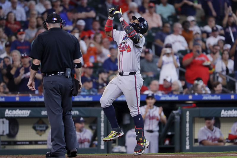 Atlanta Braves' Ronald Acuna Jr., right, celebrates his home run as he runs past home plate umpire Dan Bellino, left, during the fifth inning of a baseball game against the Houston Astros, Wednesday, April 17, 2024, in Houston. (AP Photo/Michael Wyke)