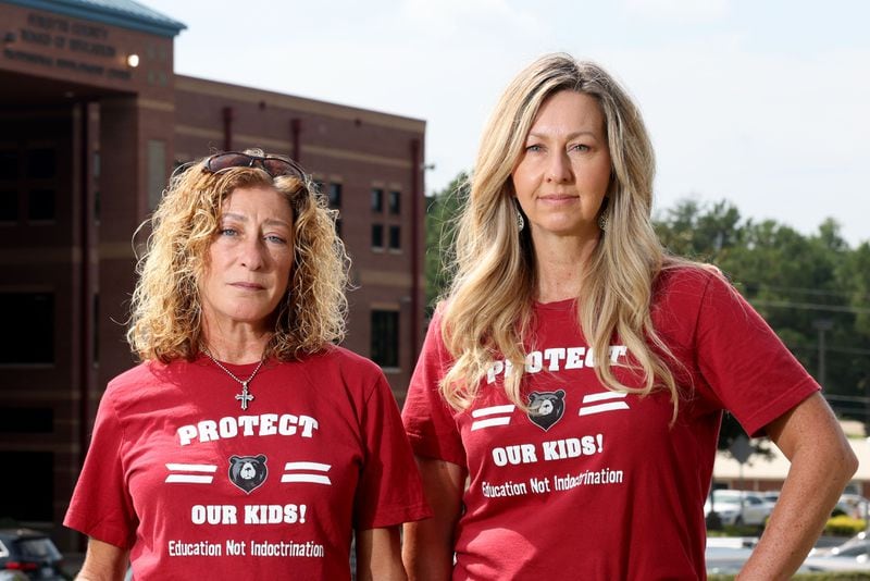 Alison Hair (left) and Cindy Martin stand in front of the Forsyth County Schools building Aug. 15, 2022, in Cumming, Georgia. They are plaintiffs in a federal lawsuit that contends their constitutional free speech rights were violated when the Forsyth school board refused to allow them to read aloud from school library books during public meetings. (Jason Getz/Atlanta Journal-Constitution/TNS)