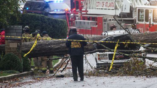 A medical examiner and Atlanta firefighters work a scene where a driver was killed after he drove his vehicle into a tree that fell on Woodhaven Road in Buckhead, Monday, Nov. 9, 2015. BRANDEN CAMP/SPECIAL