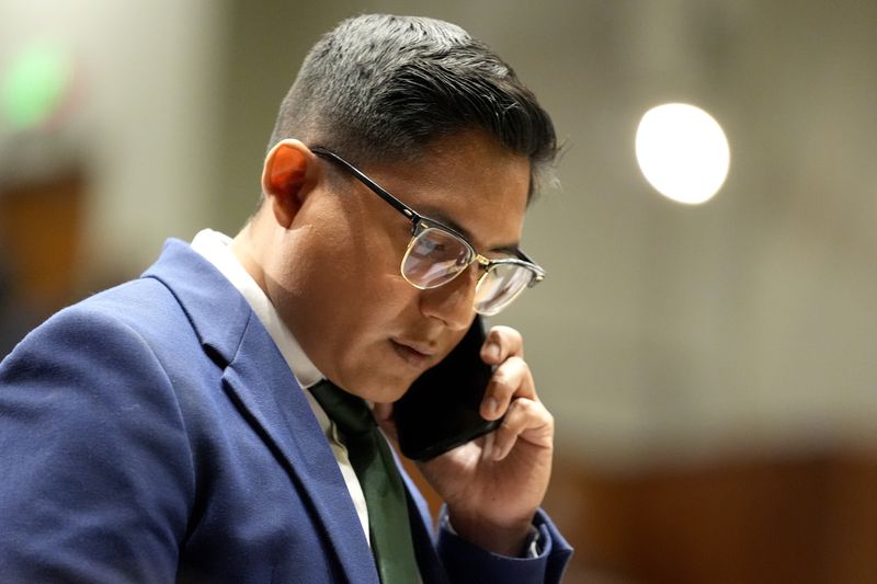 Arizona State Rep. Oscar De Los Santos, D, speaks on his phone on the House floor, Wednesday, April 17, 2024, at the Capitol in Phoenix. House Republicans have again blocked an effort for the chamber to take up legislation that would repeal Arizona’s near-total ban on abortions. (AP Photo/Matt York)