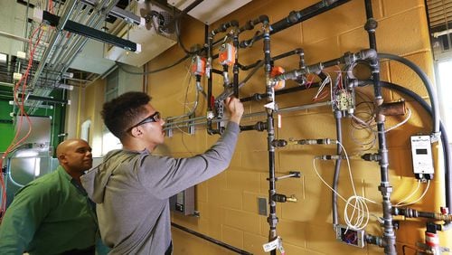Building automation instructor Robert Croom looks on while student Jomaris Soseph works on a hydronic wall during his class in the Building Automation Systems program at Georgia Piedmont Technical College on Thursday, Jan. 30, 2020, in Clarkston. CURTIS COMPTON / CCOMPTON@AJC.COM