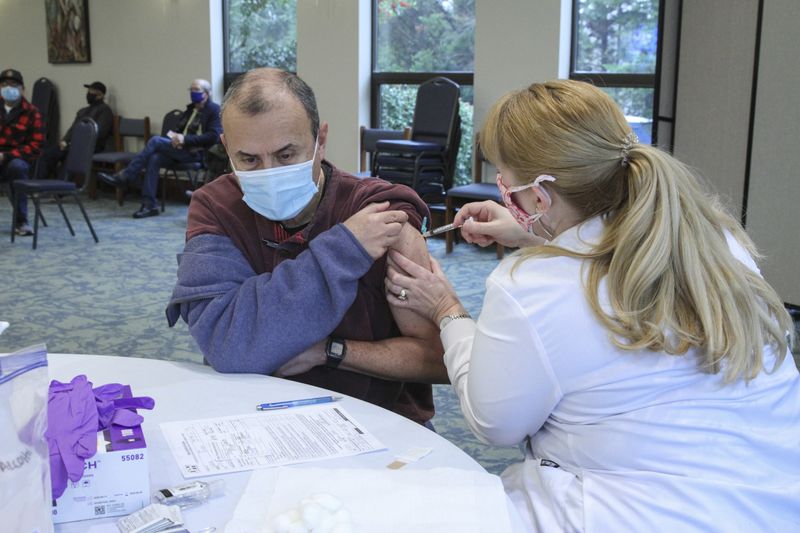 Beverly Sell, MSN, RN, of the Hall County Health Department, vaccinates St. Michael's Catholic Church parishioner Roberto Sierra. The Gainesville parish served as a vaccination site for nearly 100 members on Feb. 18. The clinic was held, in part, to increase vaccination rates in the area's Hispanic community. (Michael Alexander / Georgia Bulletin)