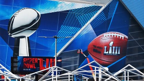 Workers use a lift to install a Super Bowl LIII wrap on the outside of Mercedes-Benz Stadium as it is transformed for the big game in Atlanta. Lowe’s, announced it is a new official sponsor of the NFL, just in time for the Super Bowl in archrival Home Depot’s hometown. Curtis Compton/ccompton@ajc.com