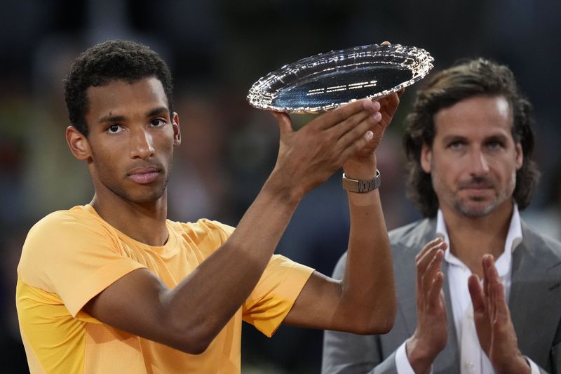 Felix Auger-Aliassime, of Canada, holds his trophy after loosing against Andrey Rublev, of Russia, in he Madrid Open men's final match in Madrid, Spain, Sunday, May 5, 2024. (AP Photo/Manu Fernandez)