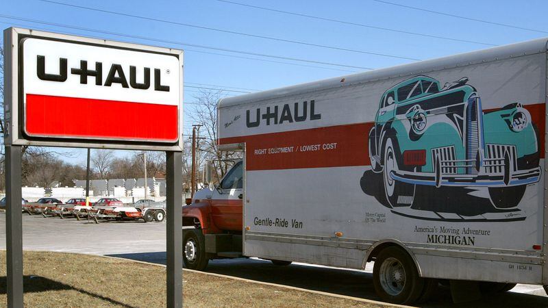 A U-Haul truck sits in front of a U-Haul store.