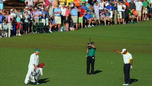 Tiger Woods takes his infamous drop on No. 15 in 2013, for which his was later penalized. (Curtis Compton/ccompton@ajc.com)