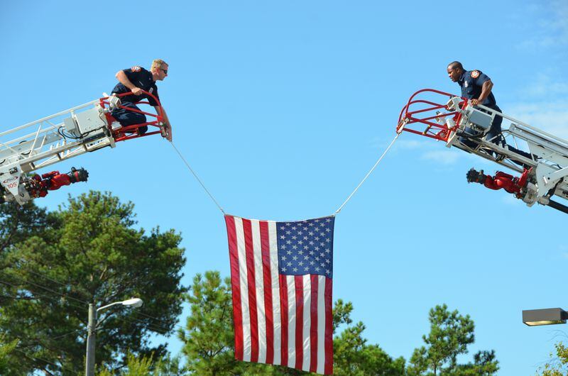 Firefighters hoist a flag at the Holy Innocents' service. Photo: Andre McIntosh