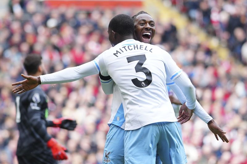 Crystal Palace's Eberechi Eze celebrates with Crystal Palace's Tyrick Mitchell after scoring his side's opening goal during the English Premier League soccer match between Liverpool and Crystal Palace at Anfield Stadium in Liverpool, England, Sunday, April 14, 2024. (AP Photo/Jon Super)