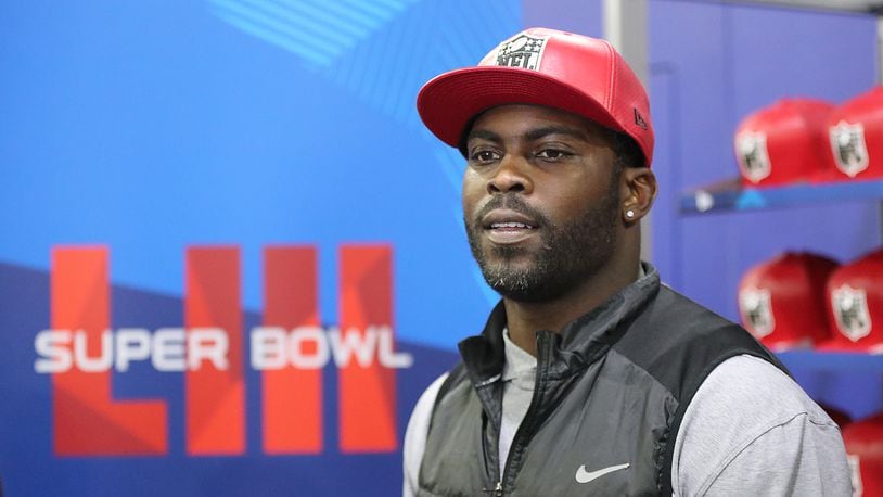 Former Falcons and Eagles quarterback Michael Vick wears one of his special edition New Era #7 hats on sale in the NFL Shop at the Super Bowl Experience on Thursday, Jan. 31, 2019, in Atlanta.  Curtis Compton/ccompton@ajc.com