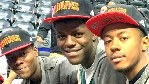 Malachi Williams (left) enjoys an Atlanta Hawks game with his brother Johnny Manuel (center) and Givonti Youngblood, all of whom are in foster care. Manuel, 19, and Youngblood, 20, will soon age out of the system. CONTRIBUTED
