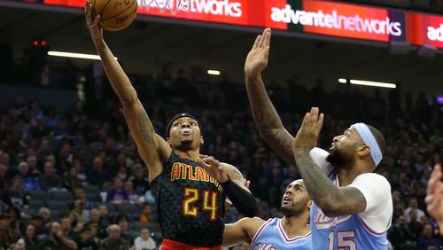 Atlanta Hawks forward Kent Bazemore, left, goes to the basket against Sacramento Kings’ Arron Afflalo, center, and DeMarcus Cousins during the first quarter of an NBA basketball game Friday, Feb. 10, 2017, in Sacramento, Calif. (AP Photo/Rich Pedroncelli)