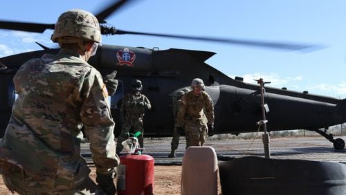 Soldiers from 227th Composite Supply Company, 101st Airborne Division, rush to refuel a Blackhawk helicopter in between missions in Sasabe, Ariz., on Nov. 20.
