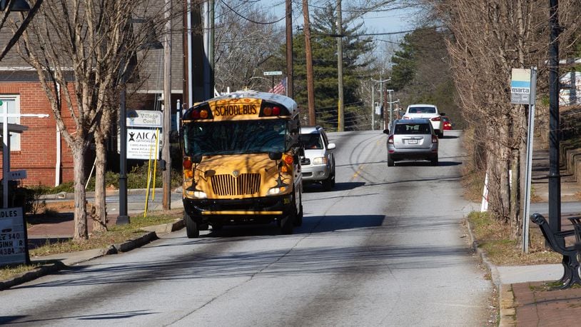  A school bus drives down Main Street in Stone Mountain Tuesday, January 18, 2022.   STEVE SCHAEFER FOR THE ATLANTA JOURNAL-CONSTITUTION
