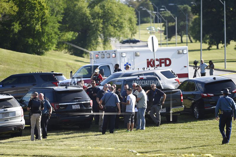 Law enforcement agents confer near the site of a shooting Thursday, July 2, 2020, in Kansas City, Mo. The shooting left a suspect dead and a police officer in critical condition after being shot in the head. The officer was hospitalized for emergency surgery, Kansas City police said on Twitter. (Tammy Ljungblad/The Kansas City Star via AP)