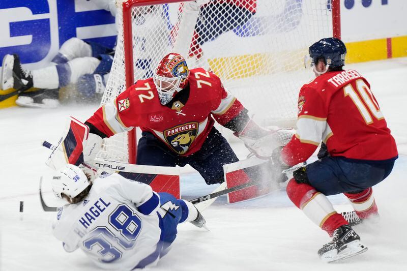 Tampa Bay Lightning left wing Brandon Hagel (38) attempts a shot as he slides across the ice against Florida Panthers goaltender Sergei Bobrovsky (72) and right wing Vladimir Tarasenko (10) during the second period of Game 2 of the first-round of an NHL Stanley Cup Playoff series, Tuesday, April 23, 2024, in Sunrise, Fla. (AP Photo/Wilfredo Lee)