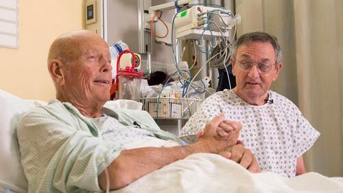 In this Nov. 5, 2015 photo, Henry "Bill" Warner, left, and John Middaugh clasp hands prior to their surgeries at NewYork-Presbyterian/Weill Cornell Medical Center in New York. Serving together in Vietnam, Warner and Middaugh forged an Army-brothers bond they knew was profound and lasting. Nearly a half a century away from the war zone where they'd counted on each other, Middaugh put himself on the line for Warner this month in a new way, by giving one of his kidneys. (AP Photo/Mark Lennihan)