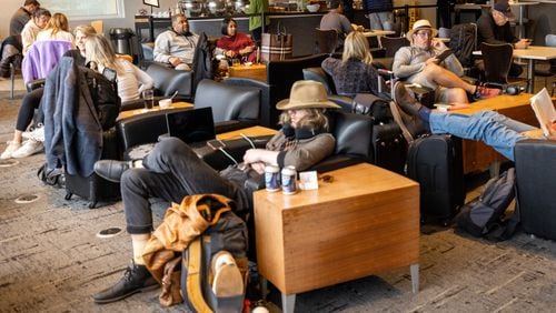 Travelers relax between flights at the Club At Atl airport Lounge Tuesday, Feb. 21.  (Steve Schaefer/steve.schaefer@ajc.com)