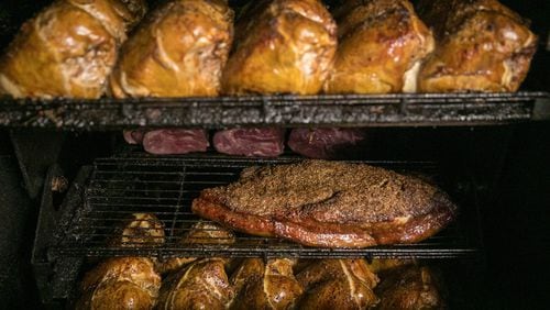 August 24, 2018- Peachtree Corners, Ga: Chicken (top) and beef brisket are shown in the smoker in the kitchen at Cue Barbecue Friday August 24, 2018, in Peachtree Corners, Ga. Cue Barbecue prides itself on all of their homemade food, including all the meat, sauces, and even the bread. This is for a feature on Cue Barbecue to be published in the October issue of Living Northside. PHOTO / JASON GETZ