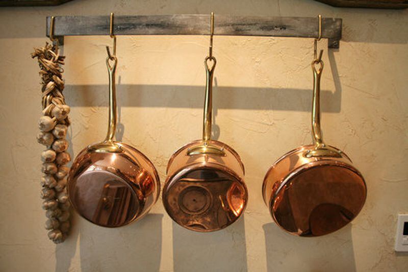 Shiny copper-clad saucepans are as decorative as they are useful, hanging at at the ready on this sturdy pot hook.