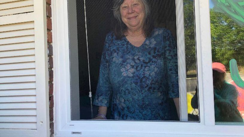 In this file photo, Marsha Tyson spends a window visit with her family on Mother's Day weekend at her nursing home in Dublin. Tyson has early-onset Alzheimer's disease and has forgotten her three children over the months of isolation and lockdown.