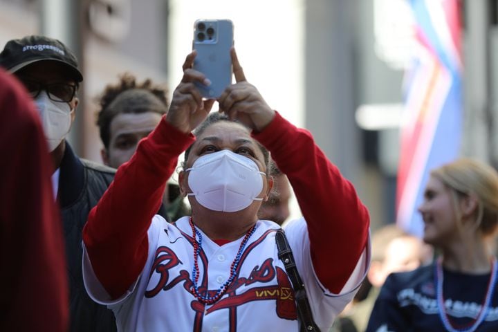 Mary Manning from Stone Mountain takes a photo of the arrival of the trophy at Colony Square. Miguel Martinez for The Atlanta Journal-Constitution 