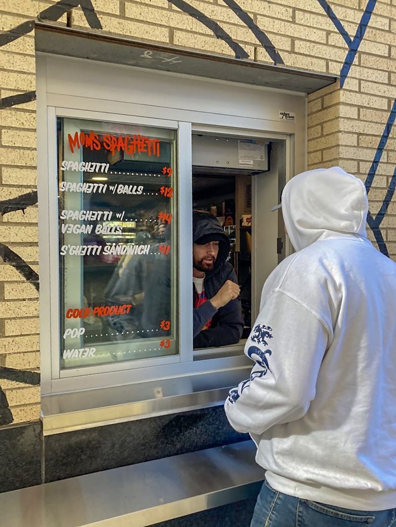 Eminem greets a patron at the window of Mom's Spaghetti on Wednesday in Detroit. 