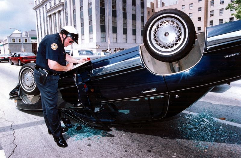 April 30, 1992: Atlanta Police Officer J.E. Price takes down information on one of the overturned cars in downtown Atlanta. (Renee' Hannans/AJC staff)