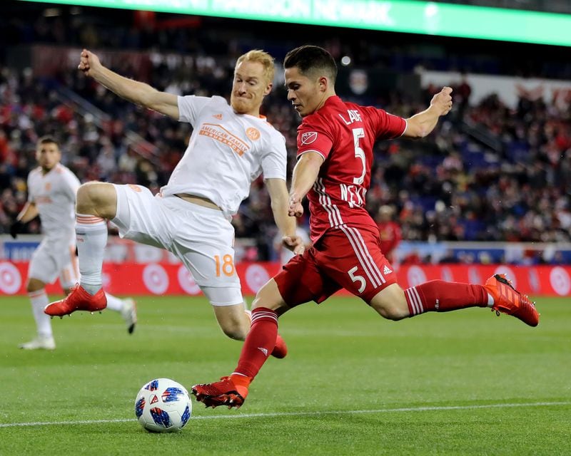 Connor Lade #5 of New York Red Bulls takes a shot as Jeff Larentowicz #18 of Atlanta United defends in the first half during the Eastern Conference Finals Leg 2 match at Red Bull Arena on November 29, 2018 in Harrison, New Jersey. (Photo by Elsa/Getty Images)