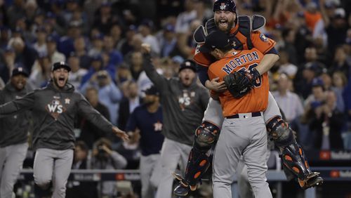 Houston Astros catcher Brian McCann leaps in the arms of starting pitcher Charlie Morton after Game 7 of baseball's World Series against the Los Angeles Dodgers Wednesday, Nov. 1, 2017, in Los Angeles. The Astros won 5-1 to win the series 4-3.