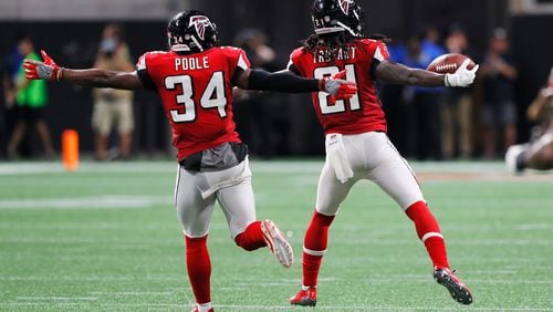 Falcons cornerback Desmond Trufant celebrates with Brian Poole after intercepting Aaron Rodgers of the Packers during the second quarter September 17 in Mercedes-Benz Stadium.