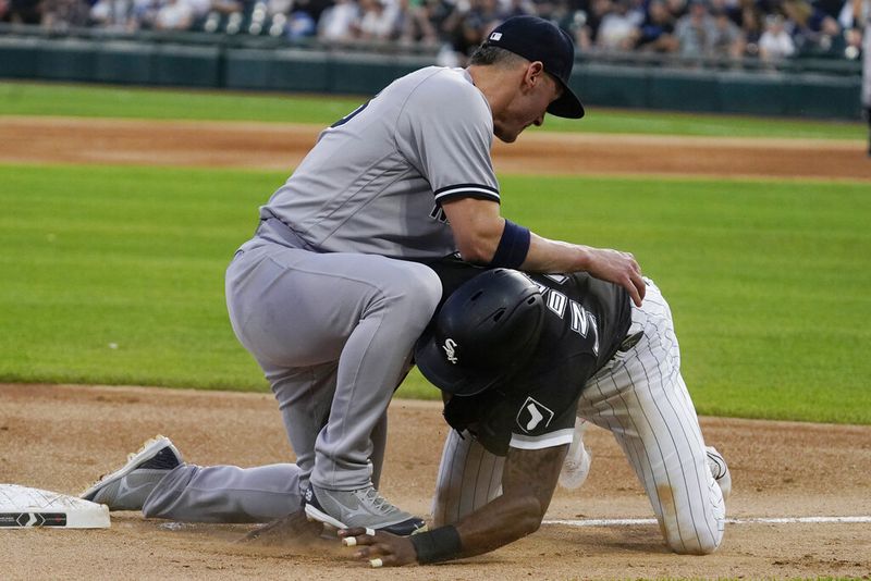Chicago White Sox's Tim Anderson, right, tries to get back to third base, next to New York Yankees third baseman Josh Donaldson during the first inning of a baseball game in Chicago, Friday, May 13, 2022. (AP Photo/Nam Y. Huh)