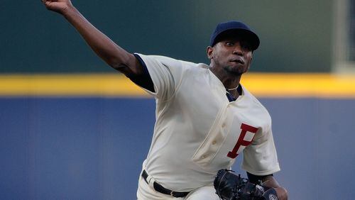 Wearing a 1914 throwback uniform to commemorate the World Series-winning Boston Braves, Atlanta Braves starting pitcher Julio Teheran delivers to the Oakland Athletics during the first inning of a baseball game Saturday, Aug. 16, 2014, in Atlanta. (AP Photo/David Tulis)