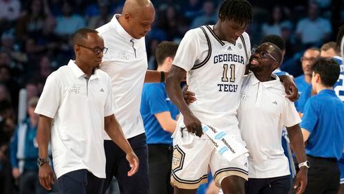 Georgia Tech forward Baye Ndongo (11) is helped off the court by training staff after an injury in the second half of an NCAA college basketball game against Duke, Saturday, Dec. 2, 2023, in Atlanta. (AP Photo/Hakim Wright Sr.)