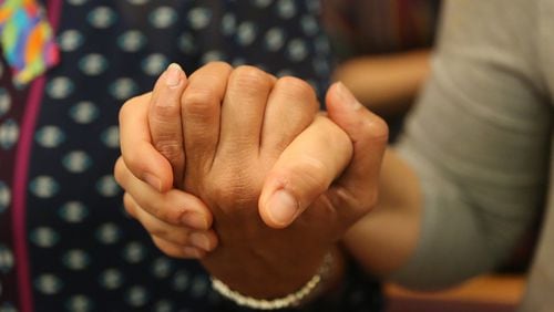 Church members hold hands during a prayer and vigil for the 49 victims at Christ Church Unity in Orlando on Wednesday. Curtis Compton/ ccompton@ajc.com