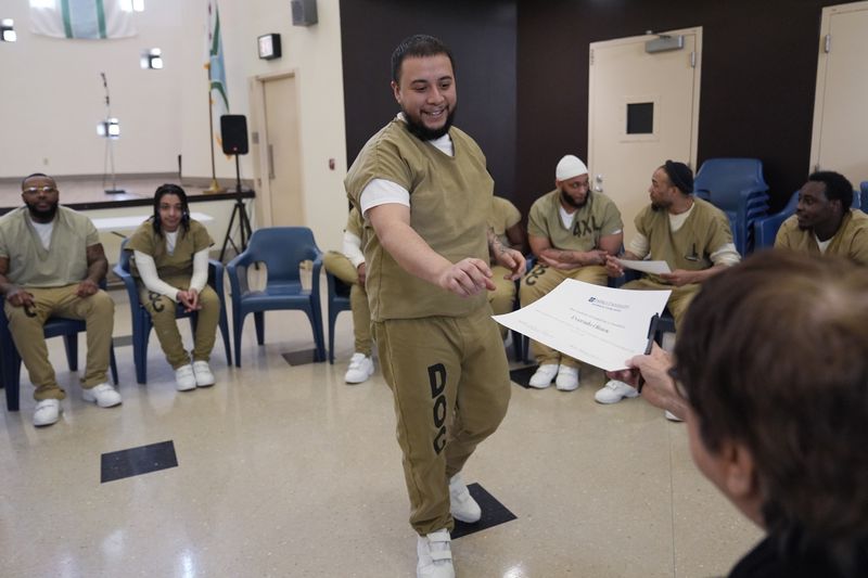Everado Olmos, detainee in Division Of Correction 11, receives a certificate after a book club at Department Of Corrections Division 11 in Chicago, Monday, April 22, 2024. DePaul students and detainees are currently reading Dead Man Walking and the author, anti death penalty advocate, Sister Helen Prejean attended to lead a discussion. (AP Photo/Nam Y. Huh)