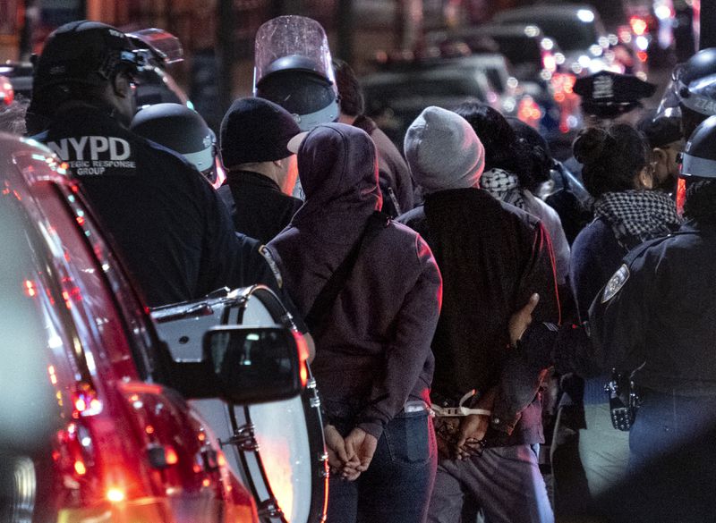 New York City police officers take people into custody near the Columbia University campus in New York Tuesday, April 30, 2024, after a building taken over by protesters earlier in the day was cleared, along with a tent encampment. (AP Photo/Craig Ruttle)