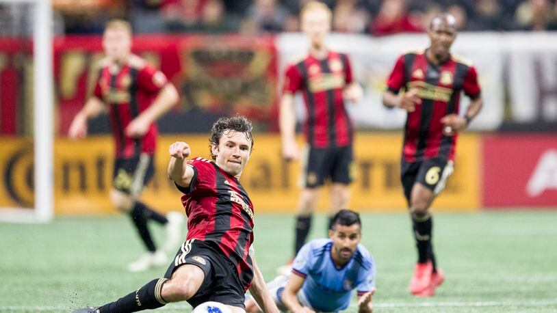 Atlanta United defender Michael Parkhurst (3) slides across the field to kick the ball during the match between NYC FC and Atlanta United at Mercedes-Benz Stadium in Atlanta, Georgia, on Sunday, April 15, 2018. (REANN HUBER/REANN.HUBER@AJC.COM)
