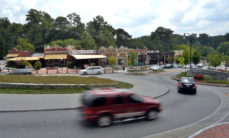 Cars drive through a traffic circle, shops and restaurants in Emory Village near an entrance to Emory University in Atlanta in this 2014 file photo. Traffic is a major concern in the university’s master plan. HYOSUB SHIN / HSHIN@AJC.COM