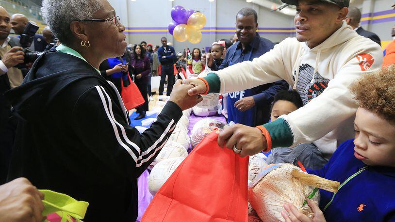 A senior citizen thanks T.I. for her Thanksgiving produce during a turkey giveaway, held at the Adamsville Recreation Center.